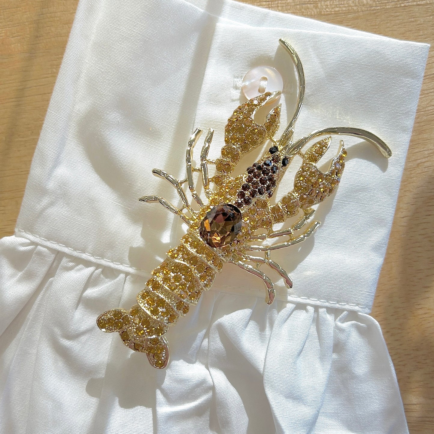 Détail broche homard doré strass