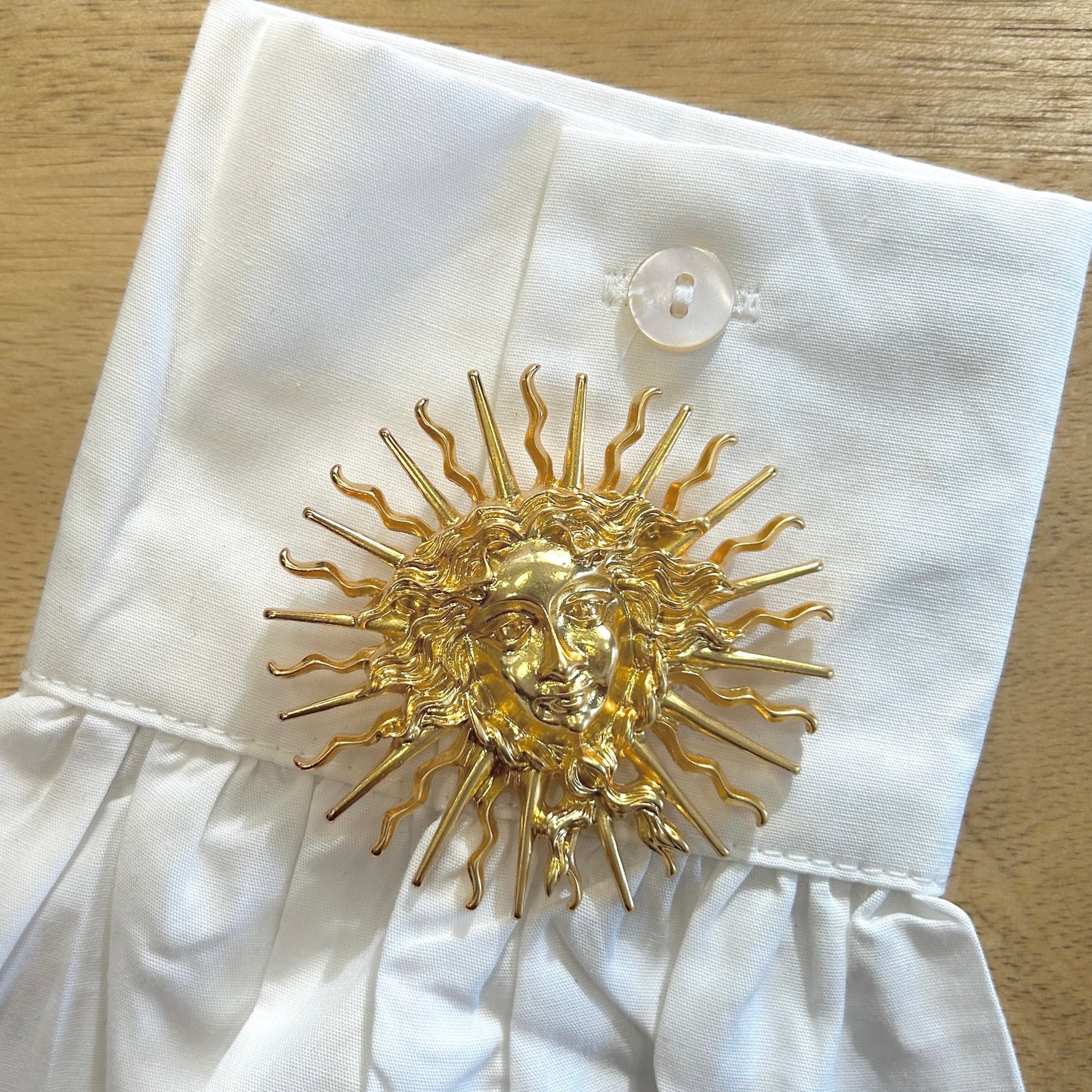 Détail broche Medusa doré visage mythologique