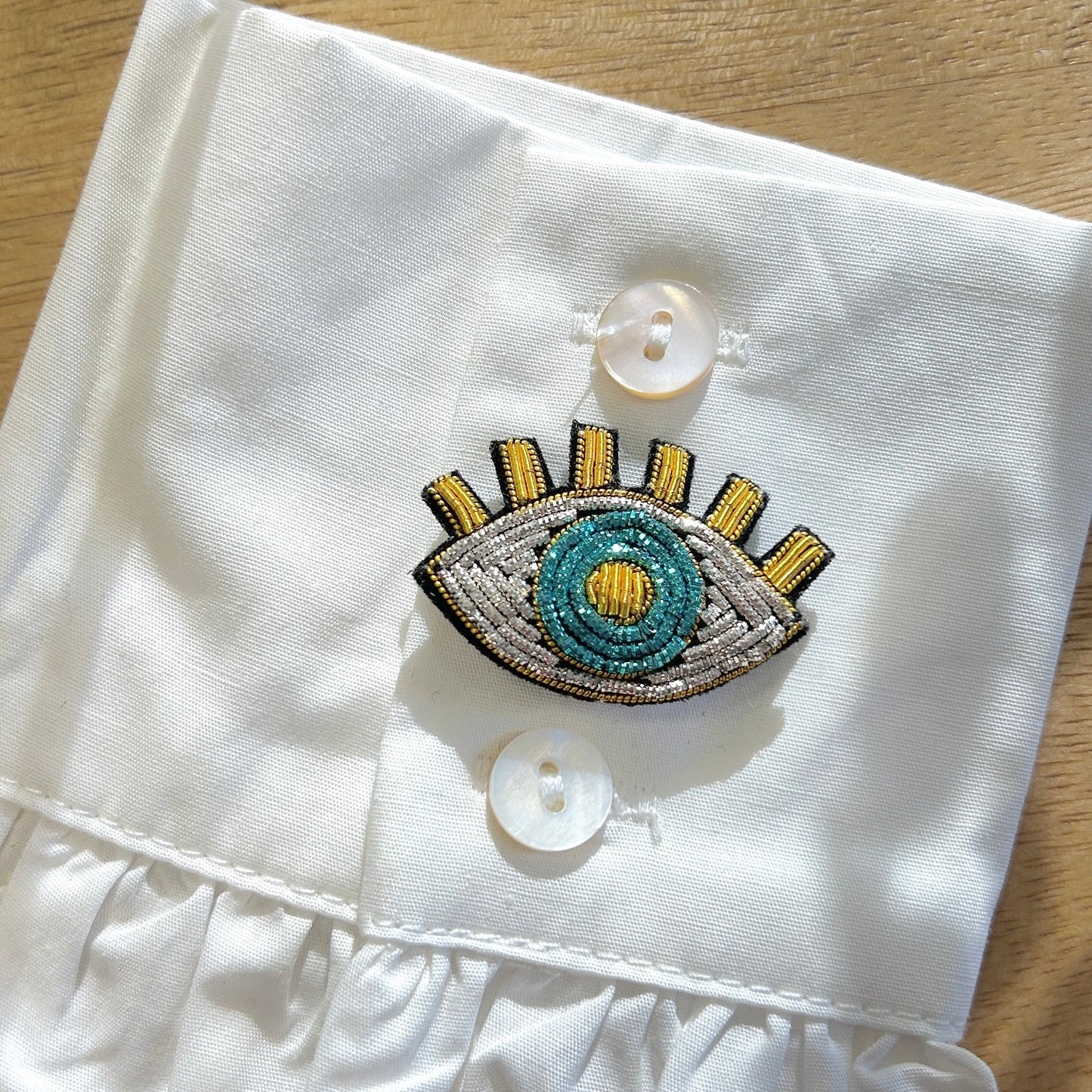 Détail broche œil bleu brodé perles