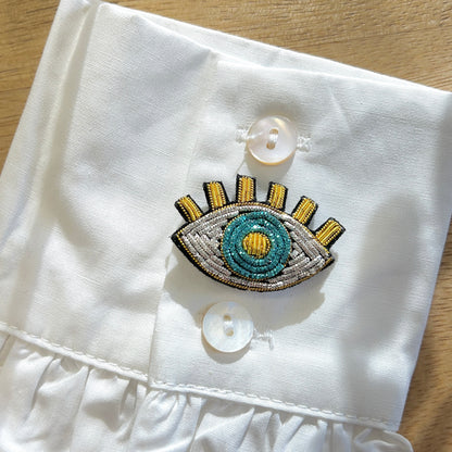 Détail broche œil bleu brodé perles
