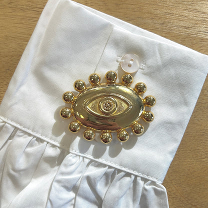 Détail broche œil doré finition brillante