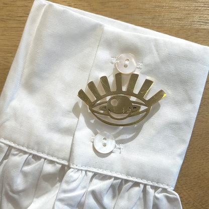 Détail broche œil doré finition métallique