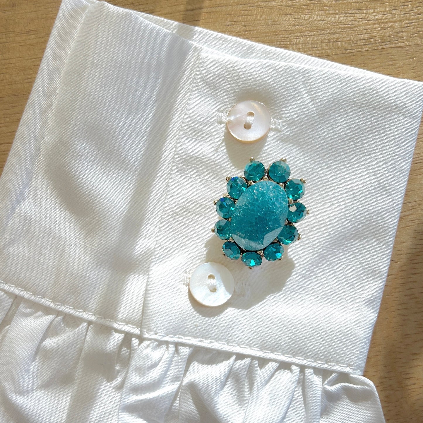 Détail broche ovale bleu turquoise strass