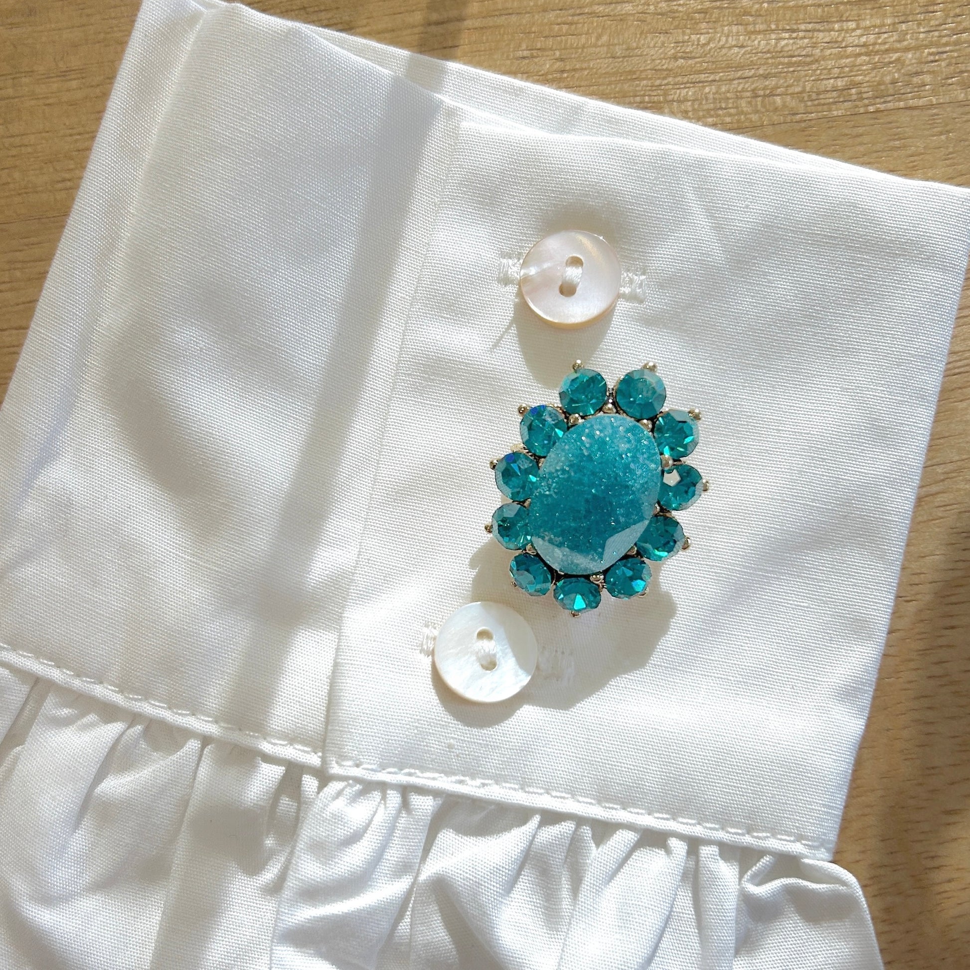 Détail broche ovale bleu turquoise strass