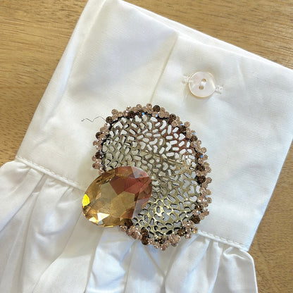 Détail broche ovale dentelle dorée strass