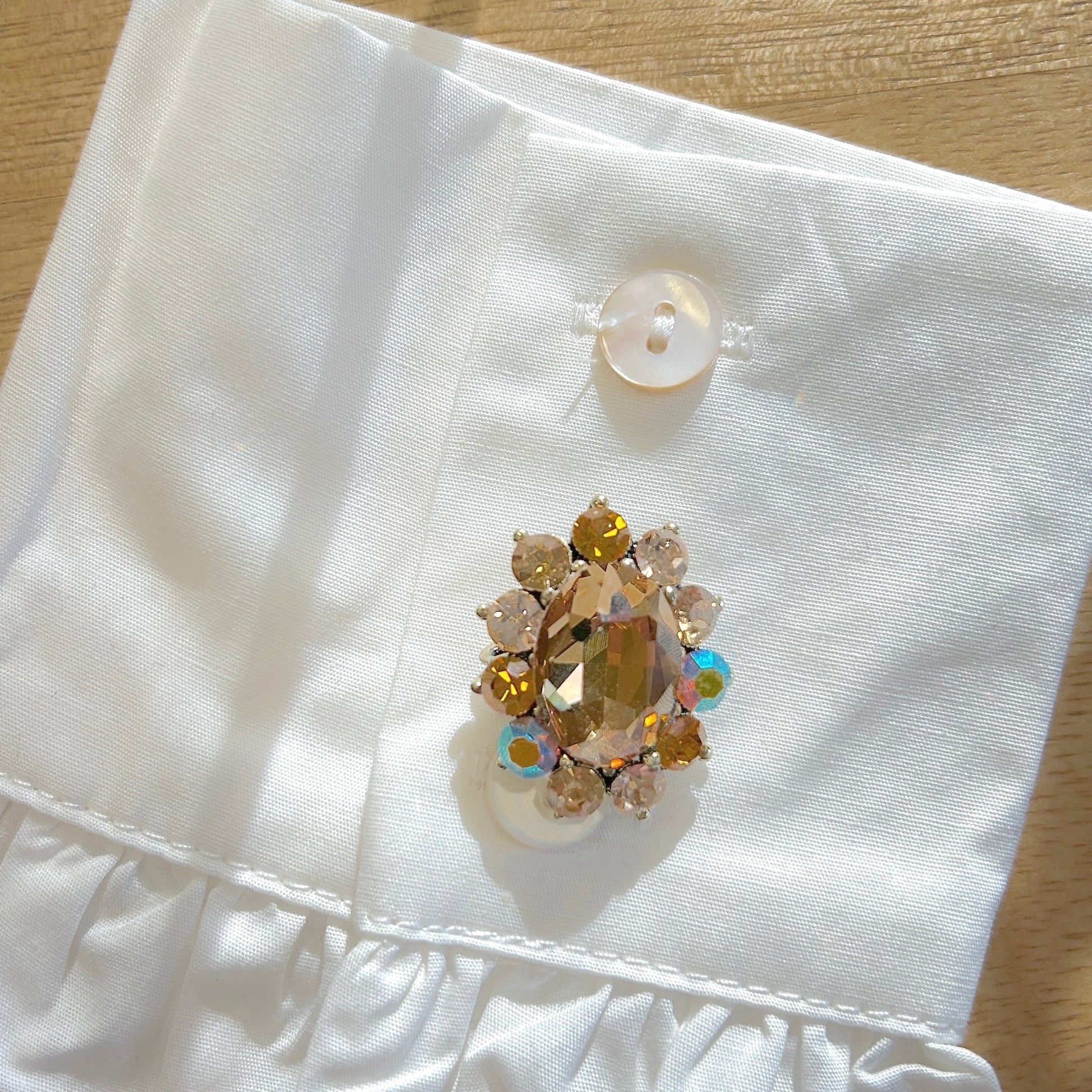 Détail broche ovale marron strass