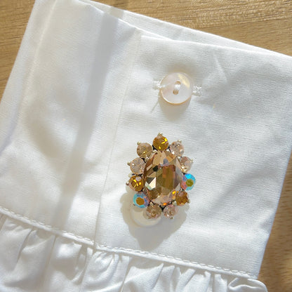 Détail broche ovale marron strass