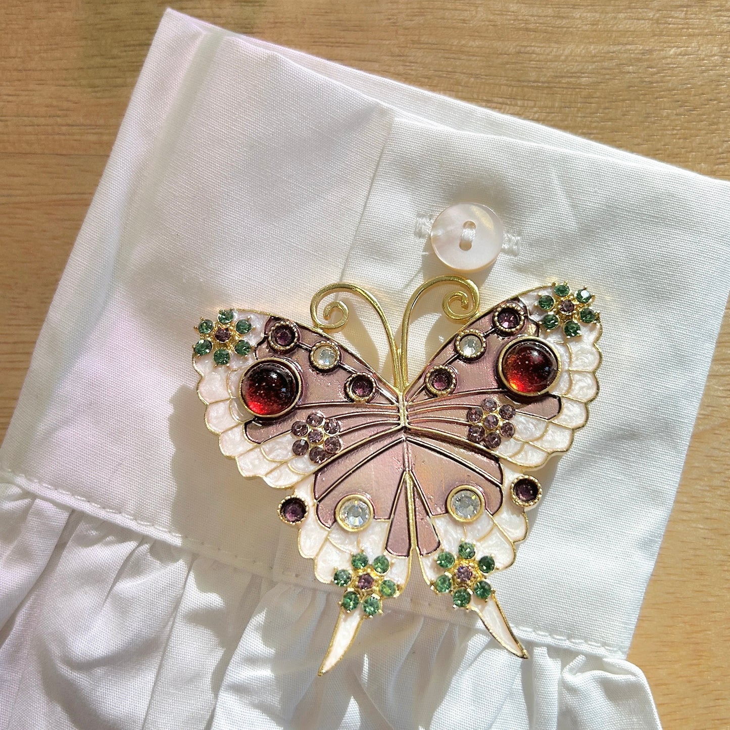 Détail de la broche papillon nude ailes serties de strass