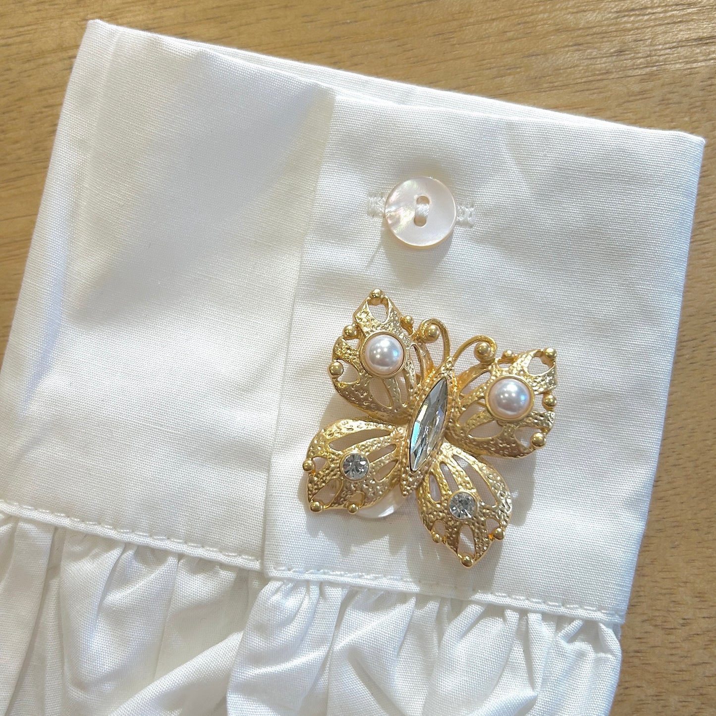 Détail broche papillon doré perles nacrées