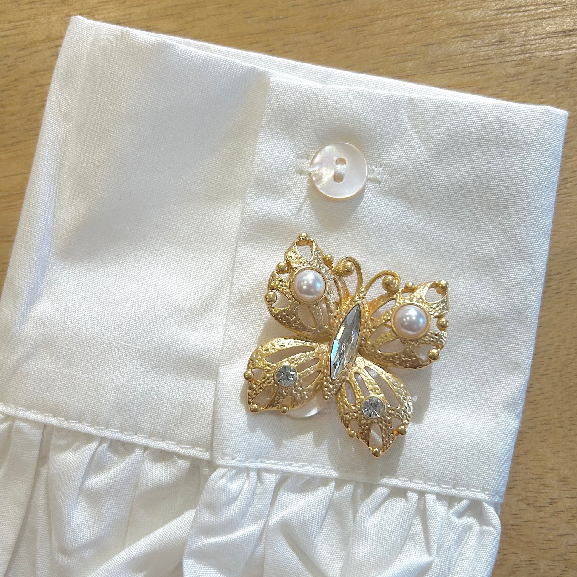Détail broche papillon doré perles nacrées