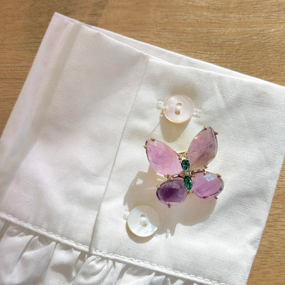 Détail broche papillon violet monture dorée