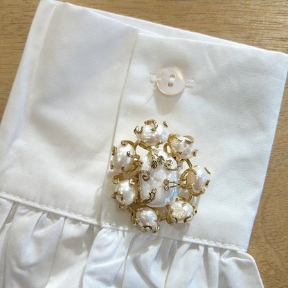 Détail broche perle baroque nacrée monture dorée