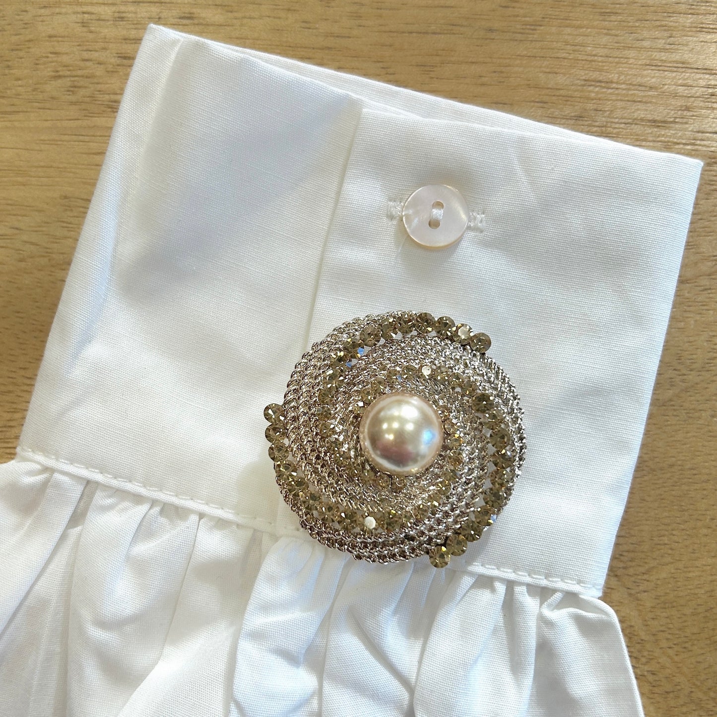 Détail broche tourbillon doré strass
