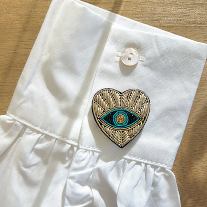 Détail broche tissu cœur œil bleu broderie