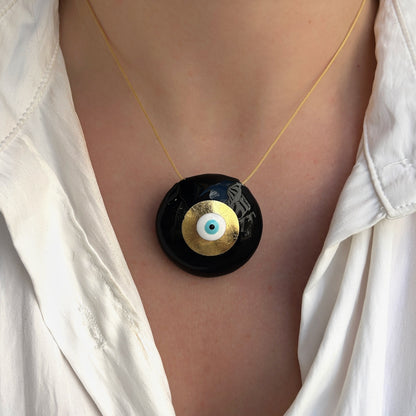 Collier Evil Eye XL Noir Sofia Papalexiou avec grand pendentif rond noir émaillé de 3,5 cm, feuille d'or et œil grec bleu turquoise sur cordon doré