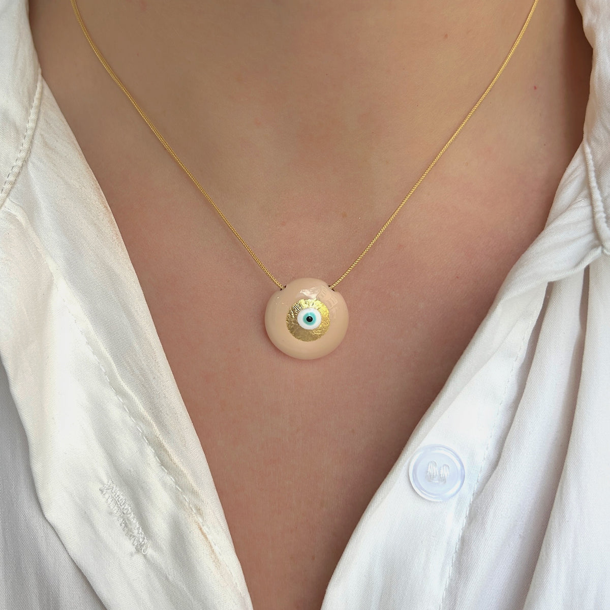 Collier Evil Eye XS Beige Sofia Papalexiou avec pendentif rond beige en laiton émaillé, œil protecteur bleu et doré, cordon réglable en macramé