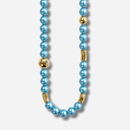 Collier Mariella Turquoise Francine Bramli Paris composé de perles rondes turquoise nacrées et d'éléments dorés sphériques et tubulaires.


