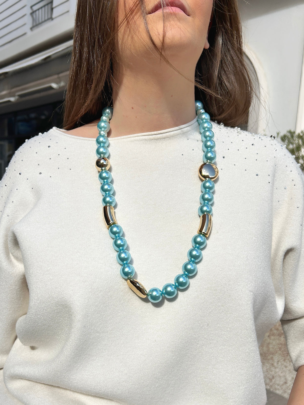 Collier Mariella Turquoise Francine Bramli Paris composé de perles rondes turquoise nacrées et d'éléments dorés sphériques et tubulaires.

