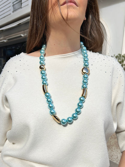 Collier Mariella Turquoise Francine Bramli Paris composé de perles rondes turquoise nacrées et d'éléments dorés sphériques et tubulaires.

