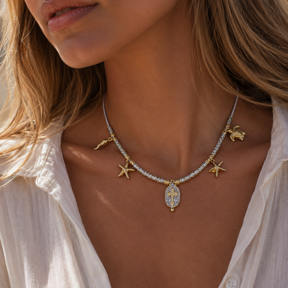 Collier Palombaggia Croix Argent Amadrina en acier doré 18K avec cristaux argentés, croix centrale et pampilles marines