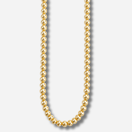 Collier Perlia Jaune Francine Bramli Paris, long sautoir composé de perles rondes jaune doré aux reflets nacrés sur fond blanc.