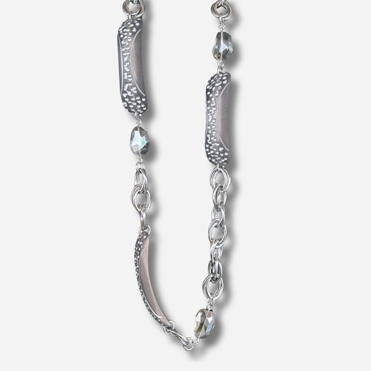Collier sautoir gris Francine Bramli Paris avec maillons argentés, éléments texturés et perles facettées porté