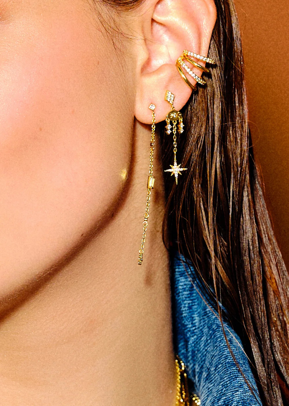 Earcuff Soho Gold MYA BAY composé de quatre anneaux dorés parallèles, deux lisses et deux sertis de cristaux blancs scintillants, chez Divinity Sète.