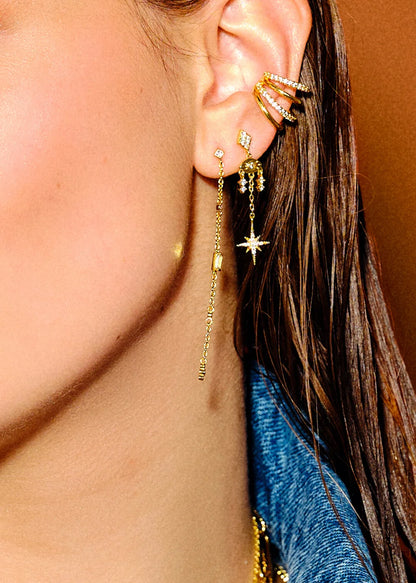 Earcuff Soho Gold MYA BAY composé de quatre anneaux dorés parallèles, deux lisses et deux sertis de cristaux blancs scintillants, chez Divinity Sète.