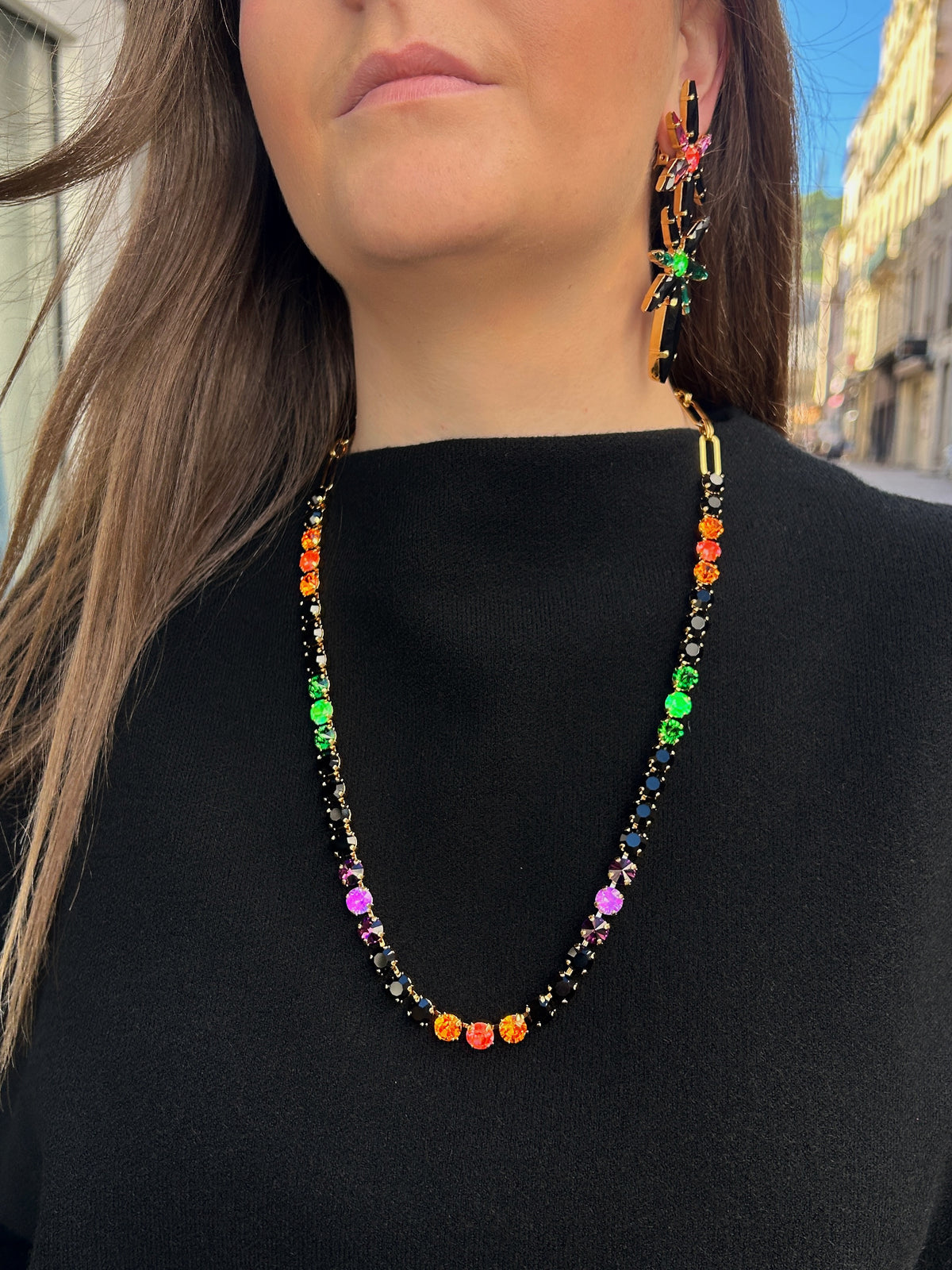 Sautoir Ava Fluo Crézus en cristaux Swarovski noirs, orange, roses, violets et verts fluo, avec sertissage doré et chaîne à maillons – Divinity Sète
