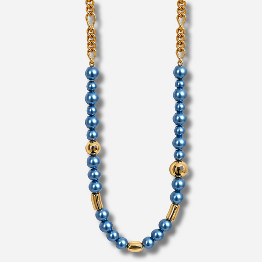 Sautoir Mariella Bleu Francine Bramli Paris, long collier composé de perles bleues nacrées de différentes tailles, de détails dorés et d'une chaîne à maillons.