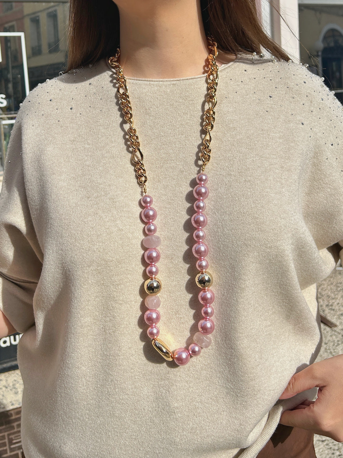 Sautoir Mariella Rose Francine Bramli Paris, long collier composé de perles roses nacrées, de perles rose pâle facettées et d'une chaîne dorée à maillons.

