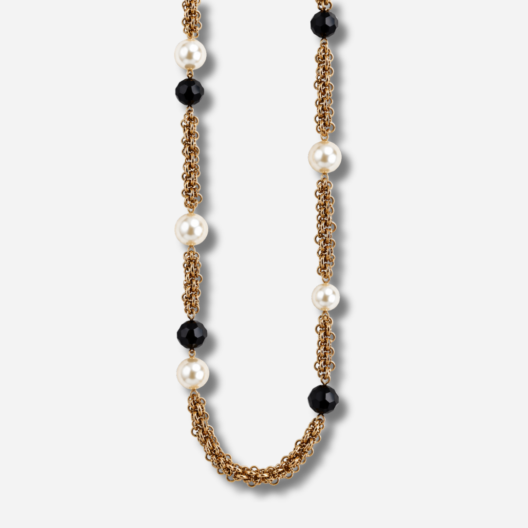 Sautoir Simple Perles Noir et Blanc Francine Bramli Paris, longues chaînes dorées ornées de perles blanches nacrées et de perles noires facettées.
