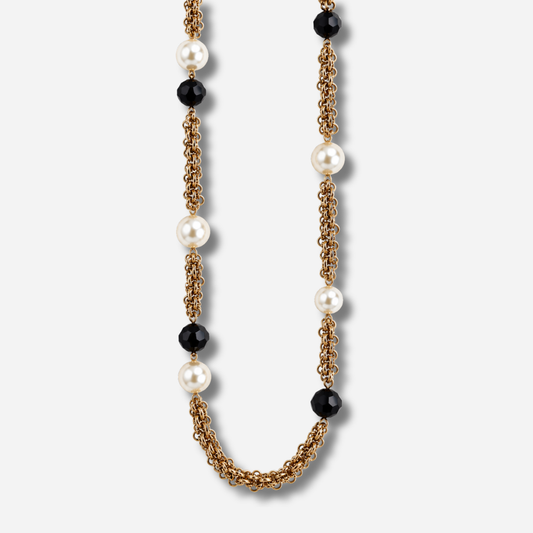 Sautoir Simple Perles Noir et Blanc Francine Bramli Paris, longues chaînes dorées ornées de perles blanches nacrées et de perles noires facettées.