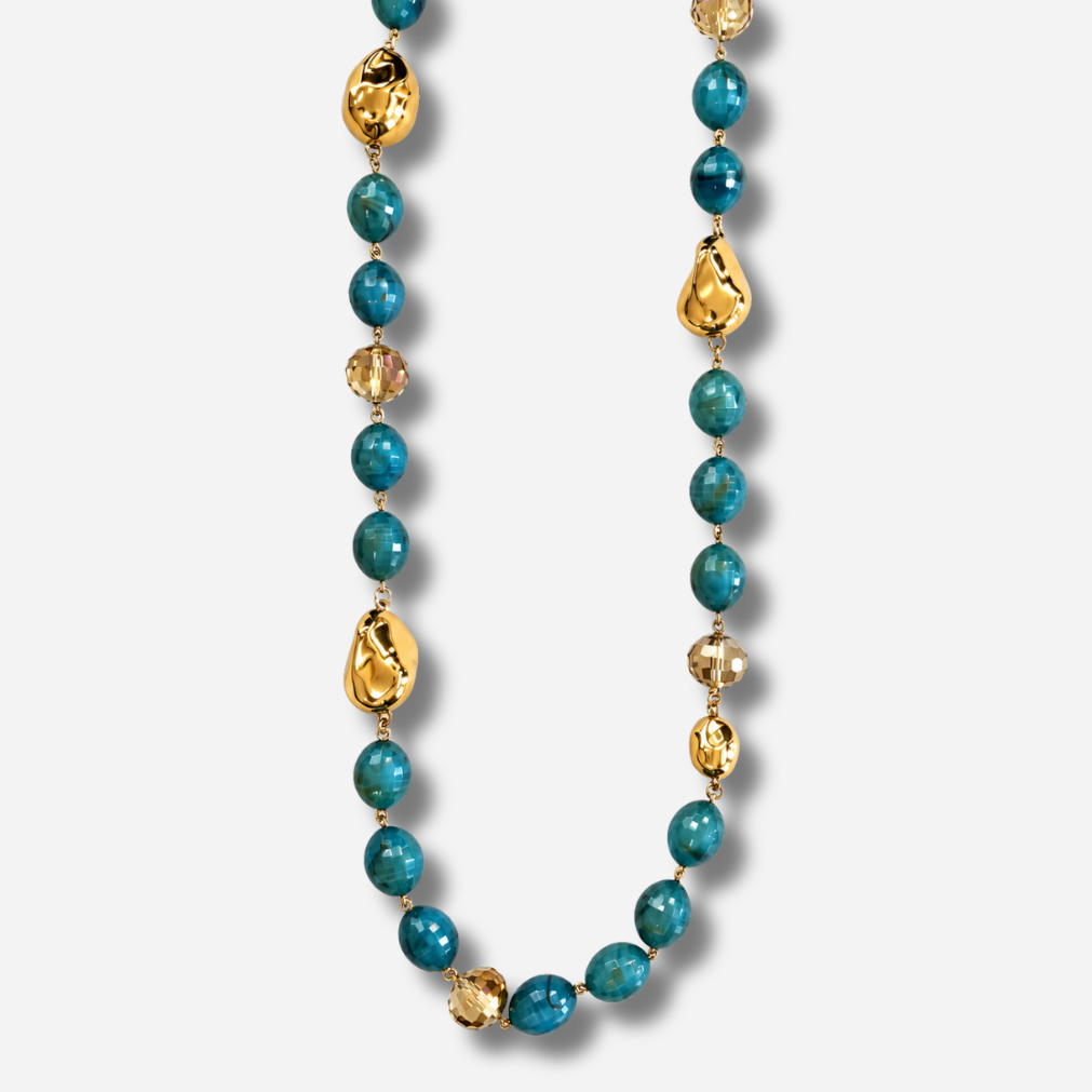 Sautoir Sonia Bleu Vert Francine Bramli Paris, collier long composé de perles ovales bleu-vert facettées, de perles champagne et d'éléments dorés irréguliers.